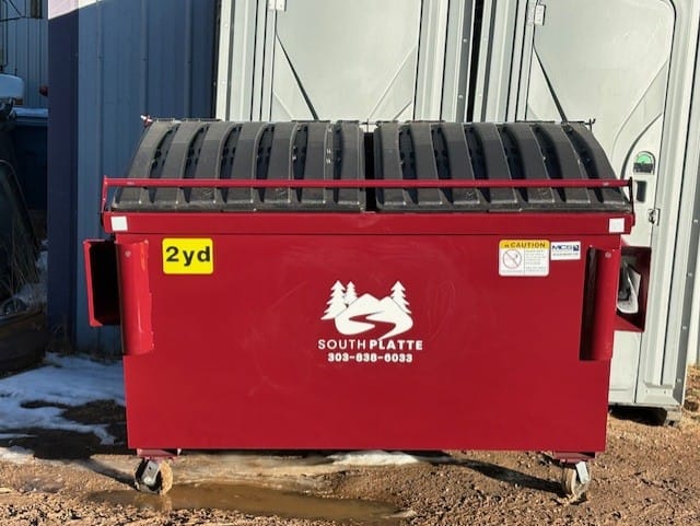 A red South Platte Services, LLC dumpster.