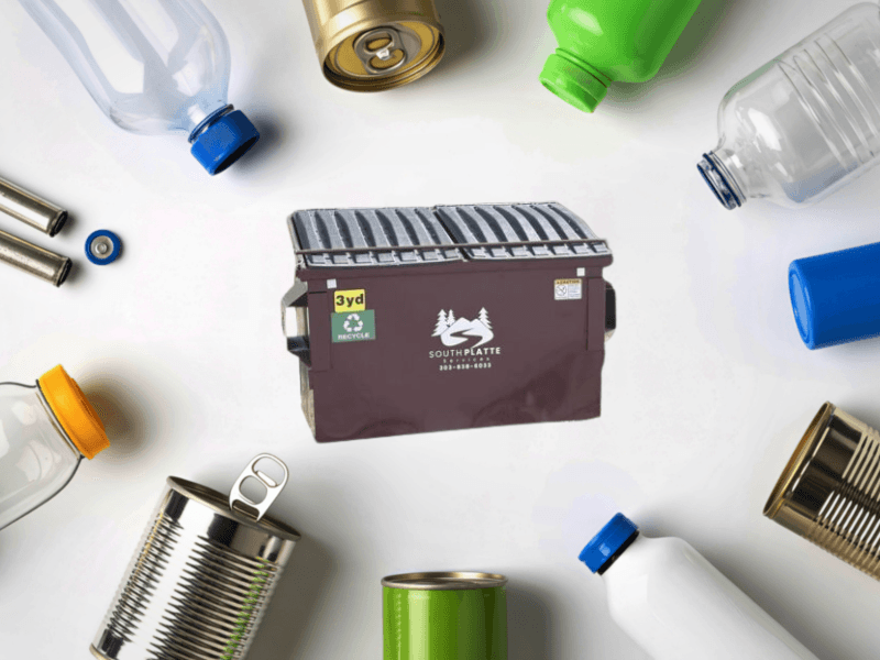 recycling dumpster with recycle items around it.