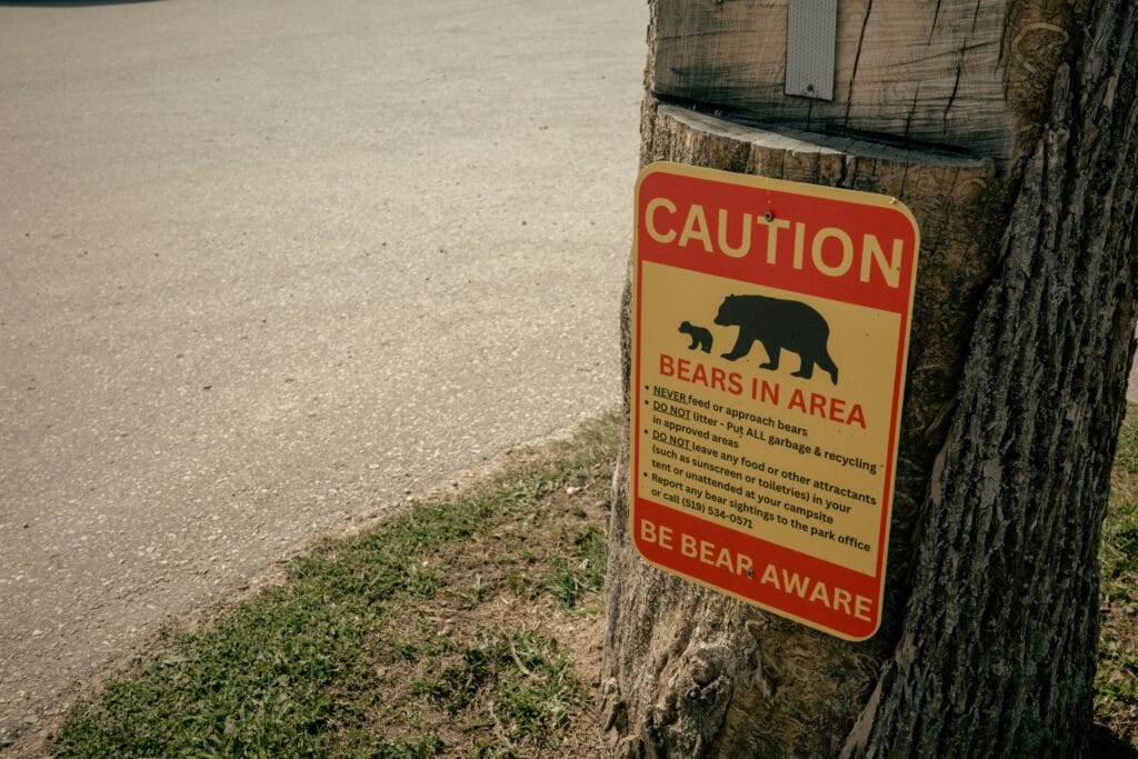 A sign wants of bears in the area and earns to not litter.